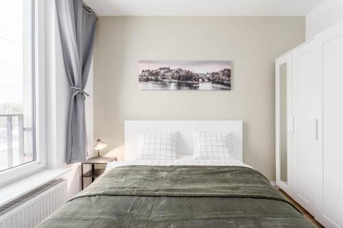 una camera da letto bianca con un letto e una finestra di Enjoy! Ursynów a Varsavia