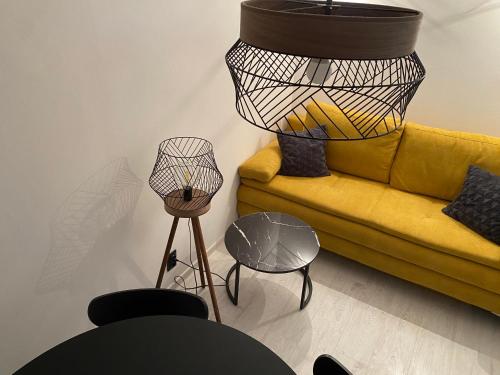 un salon avec un canapé jaune et une lampe dans l'établissement Komfortowe apartamenty w kamienicach - sercu miasta Dusznik Zdroju, à Duszniki-Zdrój