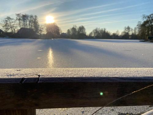 a view of a snow covered road with the sun in the background at Landhaus Lotten in Winsen Luhe