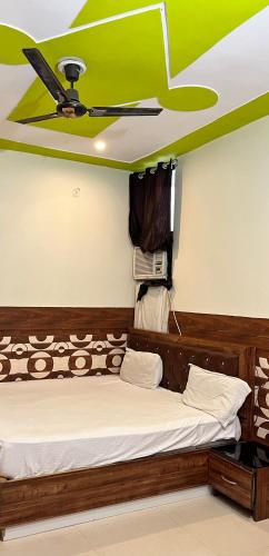 a room with a bed with a green ceiling at HOTEL COMFORT INN in Bhiwāni