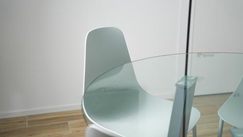 a glass table and a white chair in a room at Palazzo Gilberto in Padova