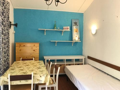 une chambre avec une table et un lit et un mur bleu dans l'établissement Maison Solane 1 Lumio, à Lumio