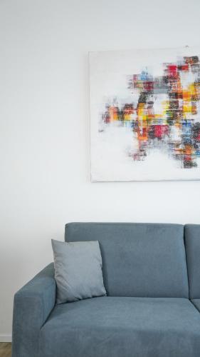 a blue couch in a living room with a painting at Palazzo Gilberto in Padova