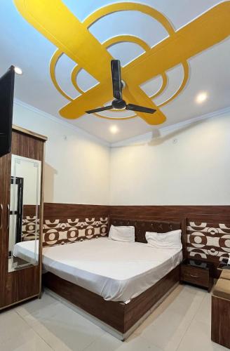 a bedroom with a ceiling fan and a bed at HOTEL COMFORT INN in Bhiwāni