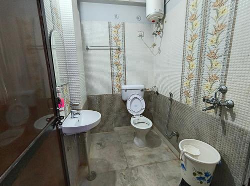 a small bathroom with a toilet and a sink at Hotel 7 Nights Jaipur in Jaipur