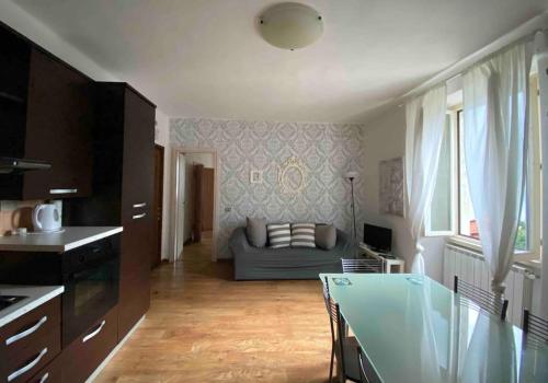 eine Küche und ein Wohnzimmer mit einem Sofa und einem Tisch in der Unterkunft Charming & bright apartment Como lakefront in Argegno