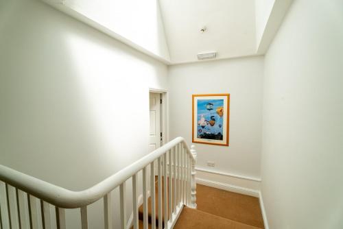 Un escalier blanc dans une maison ornée d'une peinture murale dans l'établissement Cozy Urban Retreat - Modern 1BR - Free Parking, à Bristol