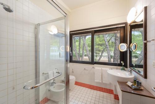 uma casa de banho com um lavatório, um WC e uma janela. em Ethra Reserve Alborèa em Castellaneta Marina