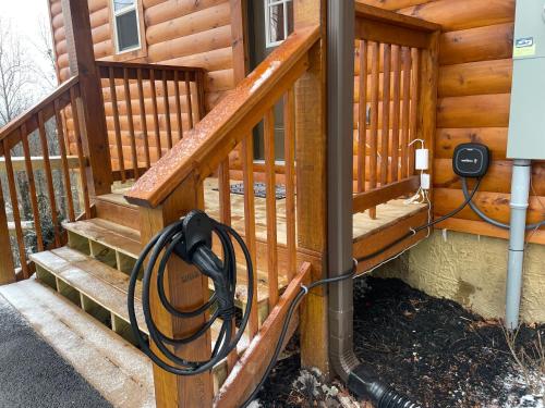 a house with a wooden staircase with a hose attached at Mountains r Calling, Cozy Hideaway, King Beds, Hot-Tub, Arcade, EV Ready in Pigeon Forge