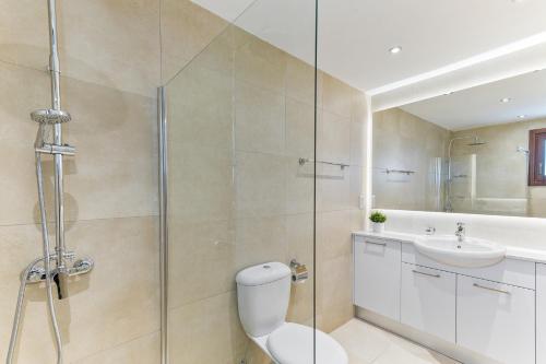 a bathroom with a shower and a toilet and a sink at 2 bedroom Apartment Thalassa with sea and sunset views, Aphrodite Hills Resort in Kouklia