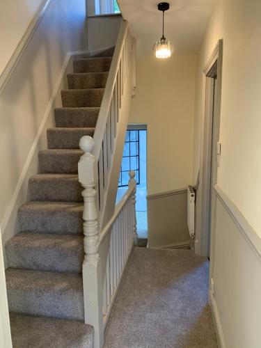 a staircase in a home with a white stair case at Orme Lodge in Llandudno