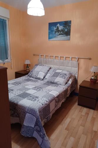 une chambre avec un lit et deux tables de nuit avec lampes dans l'établissement Maison 6 personnes vue mer, à Plougrescant