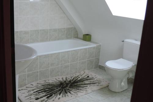 łazienka z wanną, toaletą i umywalką w obiekcie Maison 6 personnes vue mer w mieście Plougrescant