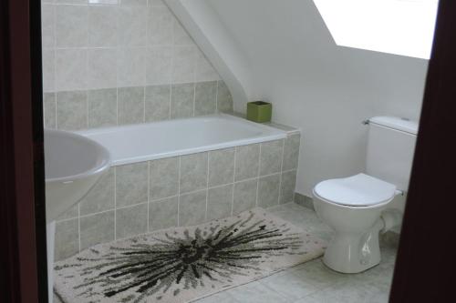 une salle de bain avec une baignoire, des toilettes et un lavabo dans l'établissement Maison 6 personnes vue mer, à Plougrescant