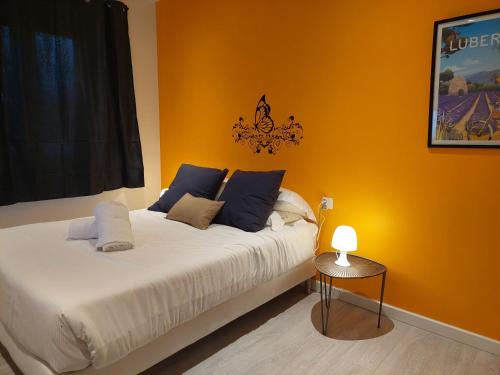 a bedroom with a bed and a table with a lamp at Hôtel Ô9 marches in Rillieux