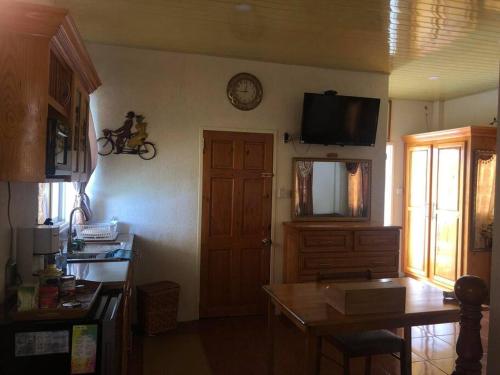 a kitchen with a table and a clock on the wall at BMB Apartment in Georgetown