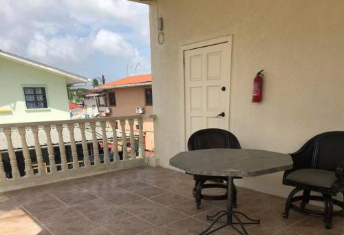 eine Terrasse mit einem Tisch und Stühlen auf dem Balkon in der Unterkunft BMB Apartment in Georgetown