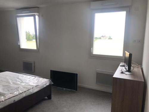 a bedroom with a bed and a desk with a television at Aladin resort in Bouconvillers