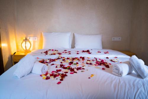 ein weißes Bett mit Blumen drauf in der Unterkunft RIAD LAICHI in Marrakesch