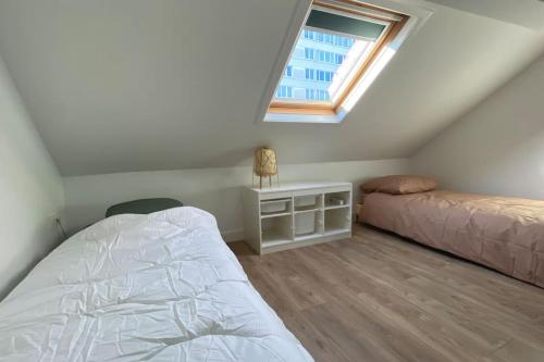 une chambre mansardée avec un lit et une fenêtre dans l'établissement Croix Centre, Maison rénovée - Maison SEB, à Croix