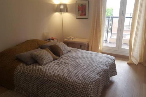une chambre avec un lit et une fenêtre dans l'établissement Appartement calme avec terrasse à 10 min de Paris, à Asnières-sur-Seine