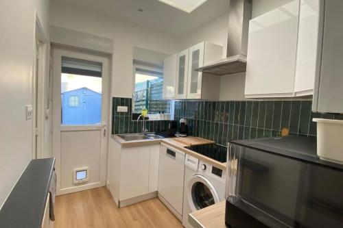 une cuisine avec des armoires blanches et une laveuse et une sécheuse dans l'établissement Croix Centre, Maison rénovée - Maison SEB, à Croix