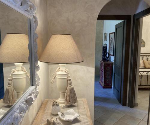 una lampada su un tavolo di fronte a uno specchio di Appartamento con terrazza Borgo San Basilio a Marina di Pisticci