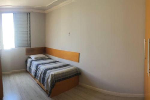 a bedroom with a bed in a room with a window at Apartamento completo, com excelente localização in Americana