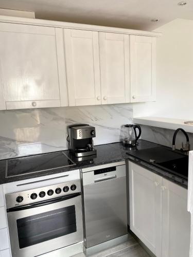a kitchen with white cabinets and a stove top oven at The Blue Beach in Sa Ràpita
