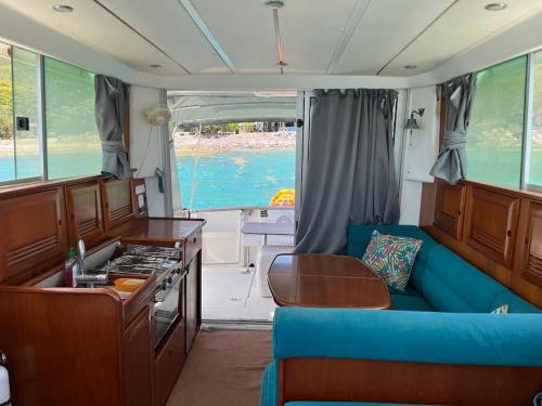 uma sala de estar com um sofá azul num barco em Bateau double cabine proche de la plage em Gourbeyre