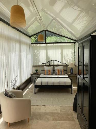 une chambre avec un lit et une chaise dans l'établissement Maison Provençale avec piscine en bord de ruisseau, à Lafare