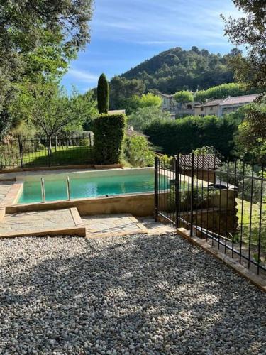 une piscine dans une cour clôturée dans l'établissement Maison Provençale avec piscine en bord de ruisseau, à Lafare