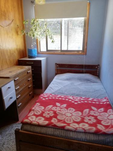 a bedroom with a bed and a dresser and a window at Departamento 4 personas central in Viña del Mar