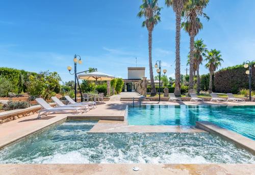 麗都馬里尼的住宿－Masseria Tenuta Specolizzi，一个带躺椅的游泳池,棕榈树