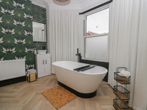 a bathroom with a white tub and a window at West End Bay in Morecambe