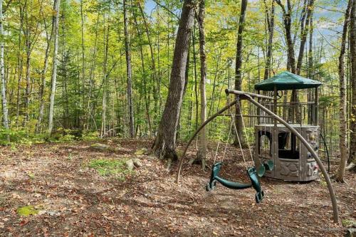 Maine Woods Treehouse-The Birdie في North Lovell: أرجوحة في وسط الغابة
