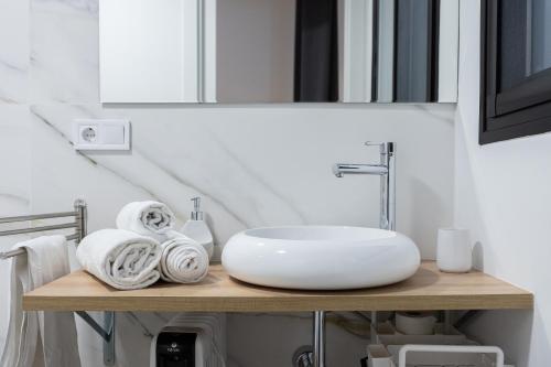 a bathroom with a sink and towels on a shelf at Victoria Inn Apartment in Valencia