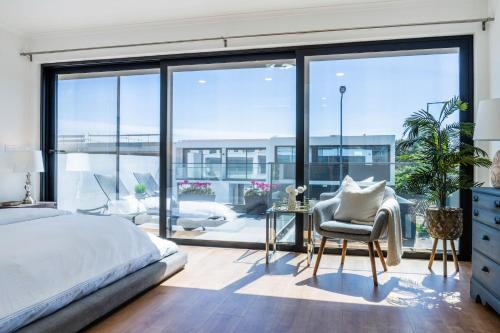 a bedroom with a bed and a large window at LUX House in Ponta Delgada