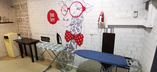 a room with a table and chairs and a wall at One Avenue Hotel Balakong in Seri Kembangan