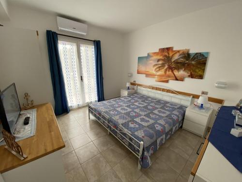 a bedroom with a bed and a table and a window at Casa vacanze Kastalia - Blu in Ragusa