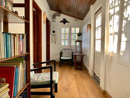 a hallway with a chair and a book shelf with books at Casa do Paço Aveiro HolidayHome in Aveiro