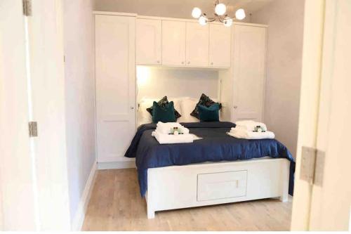 a white bedroom with a large bed with blue sheets at 5* Self Catering 1 Bed in Nenagh