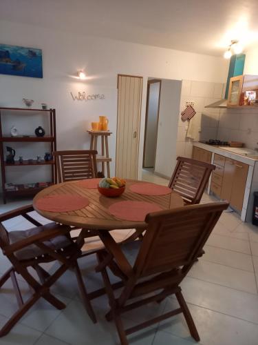 a dining room table with chairs and a bowl of fruit on it at Location Les Arômes Anse Mitan Trois Ilets Martinique in Les Trois-Îlets