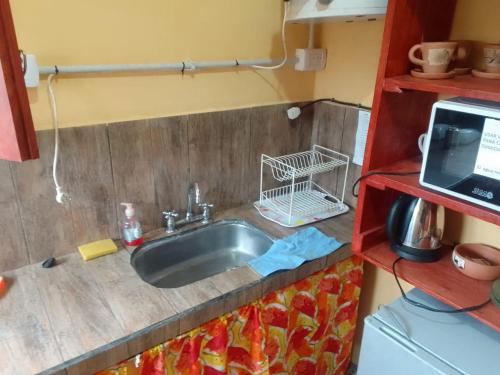 - Cocina con fregadero en una habitación pequeña en Hospedaje El Jardín en El Ceibal