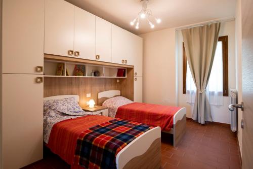 een slaapkamer met 2 bedden en een raam bij Il Pucchio in Certaldo