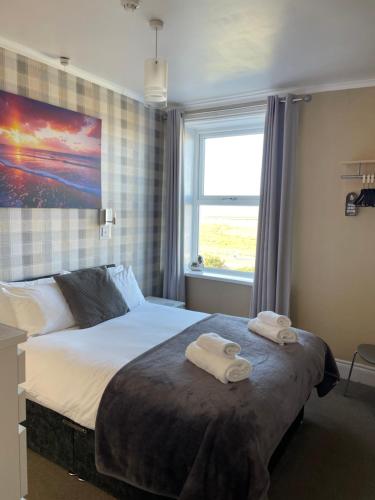 a bedroom with a bed with two towels on it at The Berkeley Morecambe in Morecambe