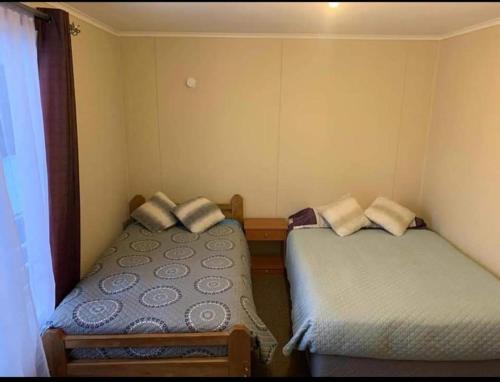 two beds in a small room at Arriendo casa por día in Villarrica