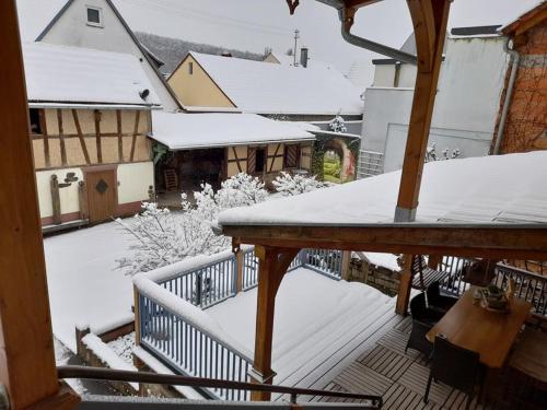 a balcony with snow on the roofs of buildings at Ferienwohnung im Theaterhof in Greußenheim