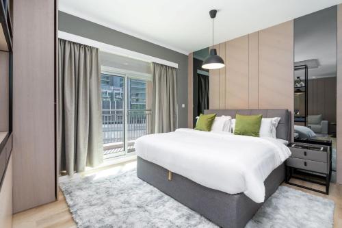 ein Schlafzimmer mit einem großen weißen Bett und einem Fenster in der Unterkunft Downtown Dubai - CityApartmentStay in Dubai