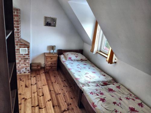 a small bedroom with a bed and a window at "Bieszczady 111"-domki nad Soliną tel, 607 - 197 - 316 in Polańczyk
